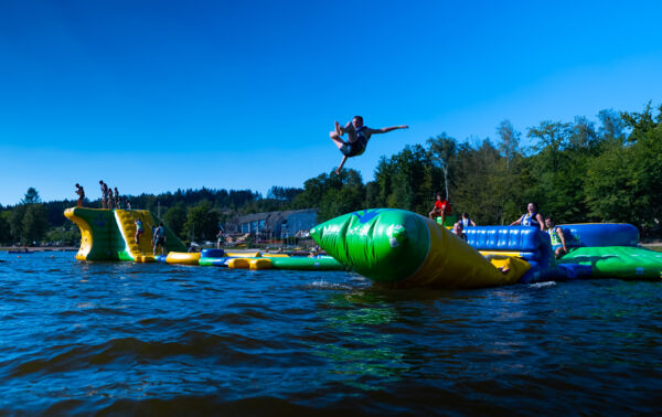 Enfant sautant depuis le module "Flip" du Wi Splash au lac des Vieilles Forges