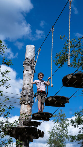 Enfant traversant une des passerelles de l'accrobranche