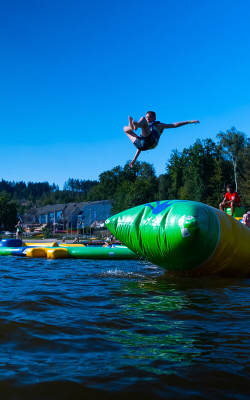 Enfant sautant depuis le module "Flip" du Wi Splash au lac des Vieilles Forges