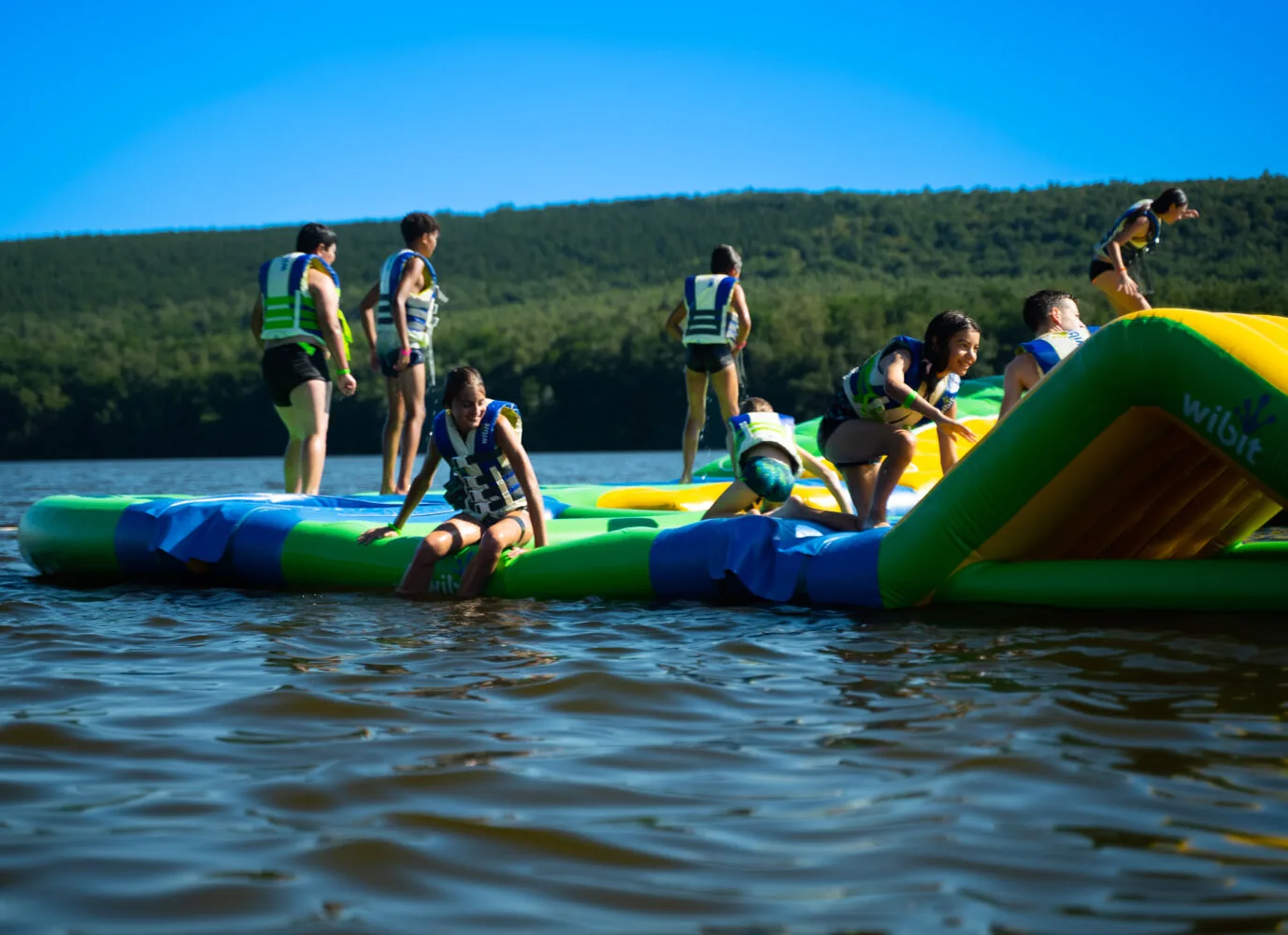 Several children climbing the “Slide” module at Wisplash, Lac des Vieilles-Forges