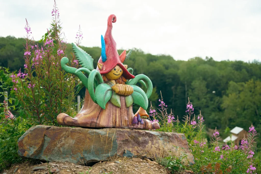 Kaboutersculptuur tussen de bloemen